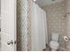 Bathroom with a toilet and a shower curtain featuring stylish geometric wallpaper at 809 Ayrshire Ave, Fort Mill, SC 29708