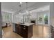 Kitchen island with stainless steel dishwasher and granite countertops overlooks the living area and fireplace at 809 Ayrshire Ave, Fort Mill, SC 29708