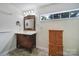 Bright bathroom with a wooden vanity, decorative mirror, and a large window at 842 Cherry S Rd, Rock Hill, SC 29732