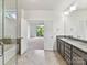 Well-lit bathroom with double sinks, modern fixtures, and a view to the bedroom at 871 Academy St, Charlotte, NC 28205