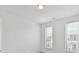 A bedroom with neutral colored walls, two windows and blinds with carpet flooring at 871 Academy St, Charlotte, NC 28205