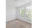 A bedroom with neutral colored walls, two windows with blinds, and carpet flooring at 871 Academy St, Charlotte, NC 28205