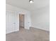 Neutral bedroom with a door to another room with carpeted floors and a closet at 871 Academy St, Charlotte, NC 28205