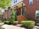 Brick townhome showcasing front entry with porch and landscaped garden at 871 Academy St, Charlotte, NC 28205