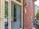 Close-up of the front door with sidelight and brick facade, showcasing the entrance details at 871 Academy St, Charlotte, NC 28205