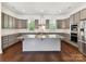 This modern kitchen features an island, stainless steel appliances, granite countertops, and gray cabinets at 871 Academy St, Charlotte, NC 28205