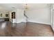Open-concept living room featuring hardwood floors, built-in shelves, and staircase at 871 Academy St, Charlotte, NC 28205
