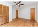 Bright bedroom featuring wood floors, white walls, ceiling fan, and closet space at 925 Rock Grove Church Rd, Salisbury, NC 28146
