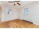Bright bedroom featuring wood floors, white walls, two windows, and ceiling fan at 925 Rock Grove Church Rd, Salisbury, NC 28146
