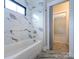 Bathroom featuring a tiled shower-tub, contemporary fixtures, and ample natural light at 9426 Greyson Ridge Dr, Charlotte, NC 28277