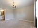 Neutral bedroom with light-gray walls, carpet, chandelier, bright windows, and shutters at 9426 Greyson Ridge Dr, Charlotte, NC 28277