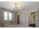 Neutral bedroom with light-gray walls, carpet, chandelier, bright windows, and shutters at 9426 Greyson Ridge Dr, Charlotte, NC 28277