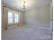 Bedroom with neutral walls, carpet, and a window with stylish light-blocking shutters at 9426 Greyson Ridge Dr, Charlotte, NC 28277