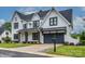 A beautiful two-story home with white siding, black trim, a gray garage door, and a well-manicured lawn at 9426 Greyson Ridge Dr, Charlotte, NC 28277