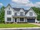 A beautiful two-story home with white siding, black trim, a gray garage door, and a well-manicured lawn at 9426 Greyson Ridge Dr, Charlotte, NC 28277