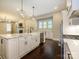 Bright kitchen features white cabinets, marble countertops, a farmhouse sink, stainless appliances, and hardwood floors at 9426 Greyson Ridge Dr, Charlotte, NC 28277