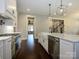 Bright kitchen features white cabinets, marble countertops, a farmhouse sink, stainless appliances, and hardwood floors at 9426 Greyson Ridge Dr, Charlotte, NC 28277