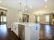 Bright kitchen features white cabinets, marble countertops, a farmhouse sink, stainless appliances, and hardwood floors at 9426 Greyson Ridge Dr, Charlotte, NC 28277