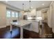 Bright kitchen boasts white cabinets, marble countertops, stainless appliances, and hardwood floors at 9426 Greyson Ridge Dr, Charlotte, NC 28277