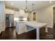 Bright kitchen boasts white cabinets, marble countertops, stainless appliances, and hardwood floors at 9426 Greyson Ridge Dr, Charlotte, NC 28277