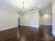 An open and bright living room with beautiful dark hardwood floors and modern chandelier at 9426 Greyson Ridge Dr, Charlotte, NC 28277