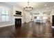 Open floor plan with hardwood floors, a fireplace, a tv, and a stylish kitchen in the background at 9426 Greyson Ridge Dr, Charlotte, NC 28277