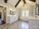 A luxurious main bathroom with dual vanities, a standalone tub, and abundant natural light at 9426 Greyson Ridge Dr, Charlotte, NC 28277