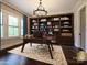 A spacious office with hardwood floors, large built-in shelves, and natural light at 9426 Greyson Ridge Dr, Charlotte, NC 28277