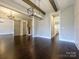 An open room with hardwood floors, beams, a chandelier, and a sliding barn door at 9426 Greyson Ridge Dr, Charlotte, NC 28277