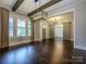 A bright room with hardwood floors, beams, a chandelier, and a sliding barn door at 9426 Greyson Ridge Dr, Charlotte, NC 28277