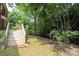Landscaped backyard features a wooded perimeter, a wooden staircase, and lawn at 9900 Colvard Cir, Charlotte, NC 28269