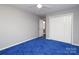 This bedroom features neutral paint, ceiling fan, blue carpet, and closet storage at 9900 Colvard Cir, Charlotte, NC 28269