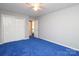 This bedroom features neutral paint, blue carpet, ceiling fan, and closet storage at 9900 Colvard Cir, Charlotte, NC 28269