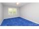 Bedroom with neutral paint, blue carpet and a large window at 9900 Colvard Cir, Charlotte, NC 28269