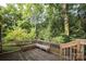 Wooden deck with built-in bench overlooking a wooded area at 9900 Colvard Cir, Charlotte, NC 28269