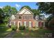 Charming two-story brick home with black shutters, mature landscaping, and a well-manicured lawn at 9900 Colvard Cir, Charlotte, NC 28269