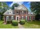 Two-story brick home with manicured lawn and mature trees, a welcoming front exterior at 9900 Colvard Cir, Charlotte, NC 28269