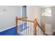 Open hallway with chandelier and staircase with wood railing and blue carpet at 9900 Colvard Cir, Charlotte, NC 28269