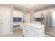 Bright kitchen featuring white cabinetry, island, and stainless steel refrigerator at 9900 Colvard Cir, Charlotte, NC 28269