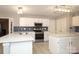 Modern kitchen featuring white cabinetry, stainless steel oven, and a large island at 9900 Colvard Cir, Charlotte, NC 28269