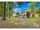 Large, private backyard with outdoor dining set, fire pit, partially fenced perimeter at 10908 Delsing Ct, Charlotte, NC 28214