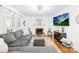 Cozy living room with brick fireplace, contemporary decor, gray sectional sofa, and abundant natural light at 10908 Delsing Ct, Charlotte, NC 28214