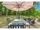 Back patio features an outdoor table with seating under a large umbrella at 10908 Delsing Ct, Charlotte, NC 28214