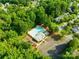 Aerial view of a community pool with lounge chairs, playground, and clubhouse nestled among lush greenery at 10908 Delsing Ct, Charlotte, NC 28214