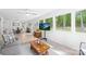 Sun room boasts a wall of windows offering views of the private wooded backyard with a small coffee table at 10908 Delsing Ct, Charlotte, NC 28214