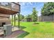 Grassy backyard with a wood fence, mature trees, and a patio for outdoor relaxation and entertaining at 11043 Stetler St, Charlotte, NC 28204
