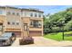 Three-story townhome with brick facade, a two-car garage, and landscaped front yard offering curb appeal at 11043 Stetler St, Charlotte, NC 28204