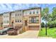 Three-story townhome with brick facade, a two-car garage, and landscaped front yard offering curb appeal at 11043 Stetler St, Charlotte, NC 28204
