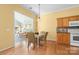 Cozy dining area open to kitchen, with hardwood floors, yellow walls, and living room view at 1107 Rachel Anne Dr, Belmont, NC 28012
