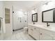 Modern bathroom with black hardware, white cabinets, dual sinks, tiled floors and shower with glass door at 1121 S Wendover Rd, Charlotte, NC 28211